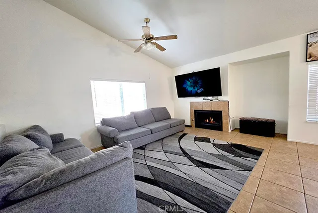 a living room with furniture a flat screen tv and a fireplace