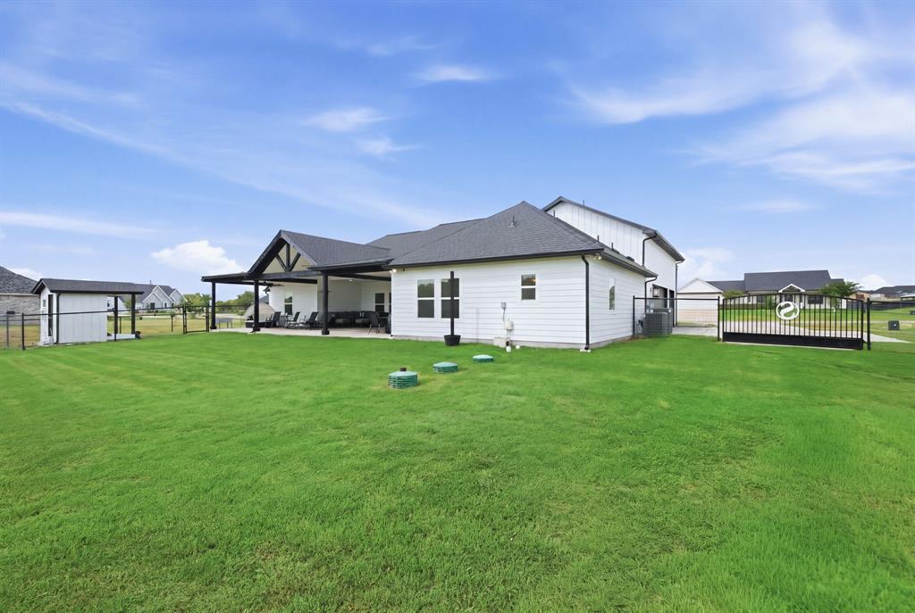10216 Finch Road Sanger, TX 76266 - Photo 29 of 40 Expansive backyard featuring a manicured lawn, covered patio, and a separate storage shed - Virtual Grass