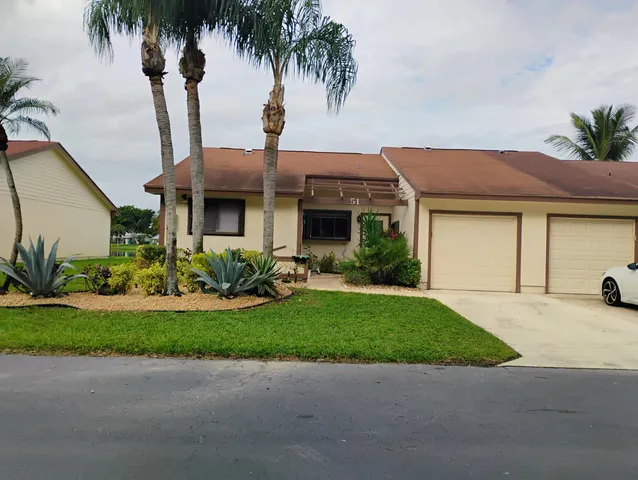 a front view of a house with garden and patio