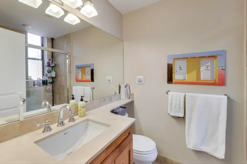 a bathroom with a sink vanity mirror and toilet