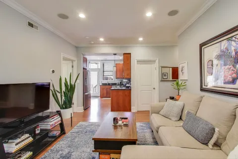 a living room with furniture a flat screen tv and a large window