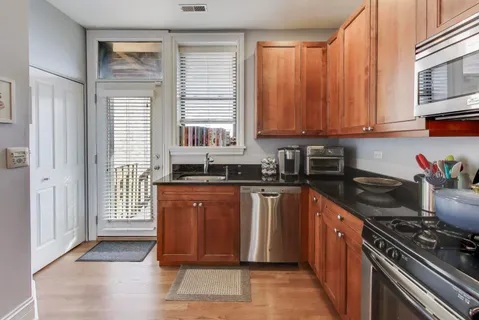 a kitchen with stainless steel appliances granite countertop a stove a sink and a microwave