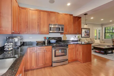 a kitchen with stainless steel appliances granite countertop a stove a sink and a microwave