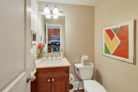 a bathroom with a sink vanity mirror and toilet
