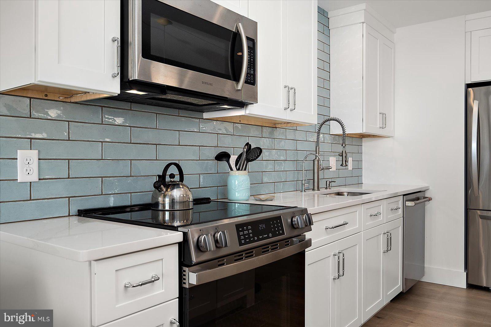 609 Dory Road, Unit 304 Ocean City, MD 21842 - Photo 15 of 55 a kitchen with stainless steel appliances a sink stove and microwave