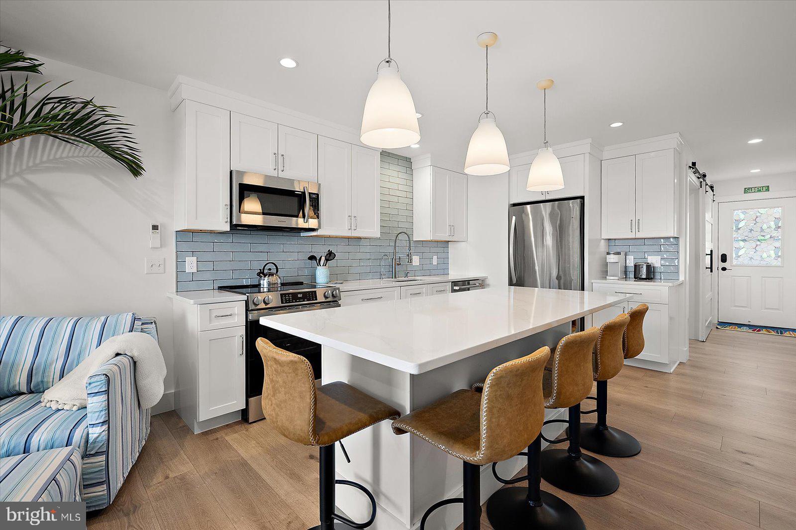609 Dory Road, Unit 304 Ocean City, MD 21842 - Photo 16 of 55 a kitchen with stainless steel appliances granite countertop a stove a sink a refrigerator a microwave a island and chairs