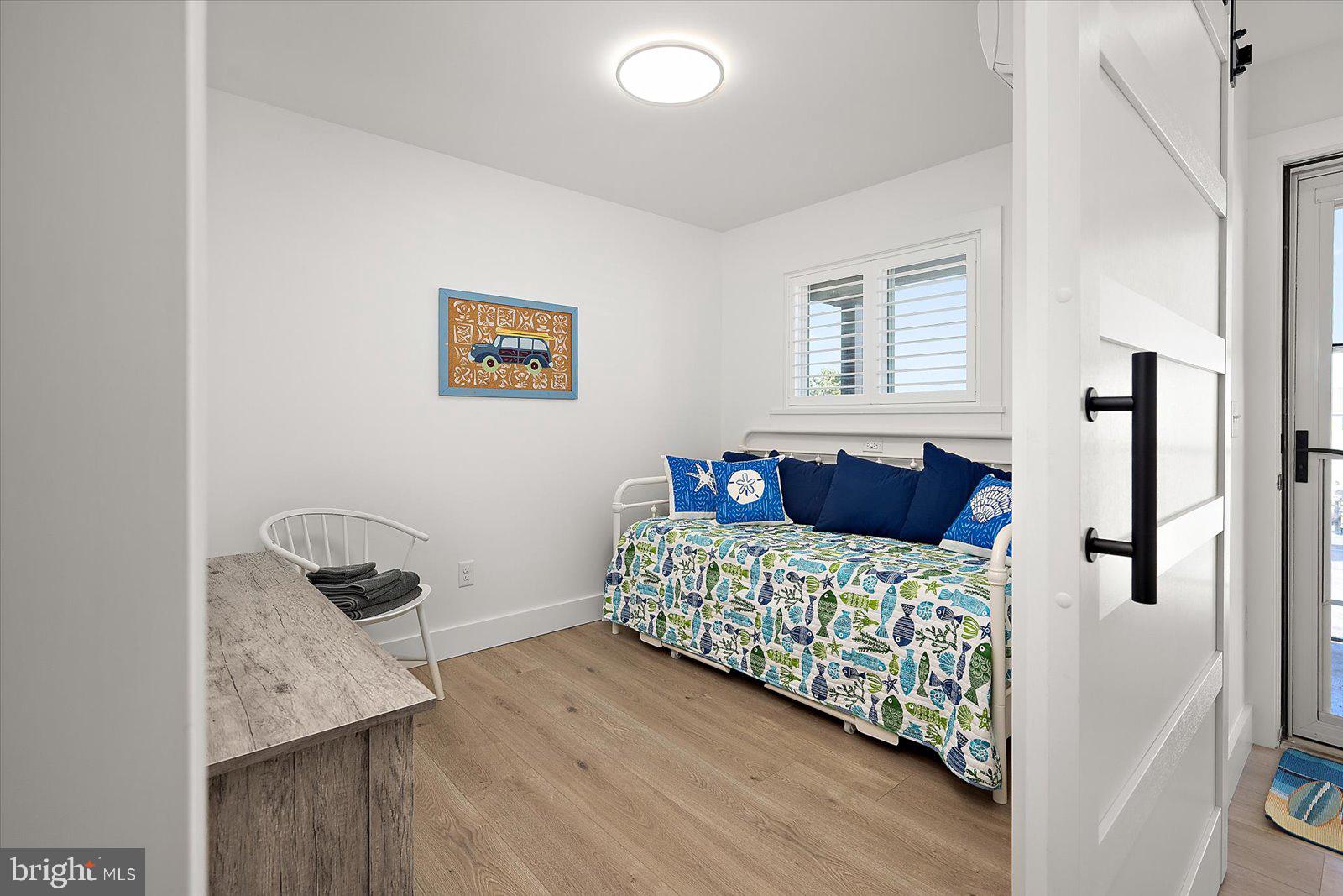 609 Dory Road, Unit 304 Ocean City, MD 21842 - Photo 34 of 55 a bedroom with a bed and wooden floor
