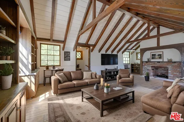 a living room with furniture a fireplace and a dining table