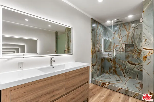a bathroom with a sink mirror and shower