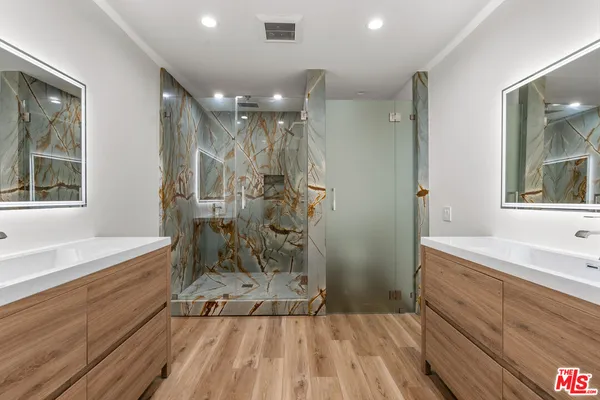 a bathroom with a sink a large mirror and shower