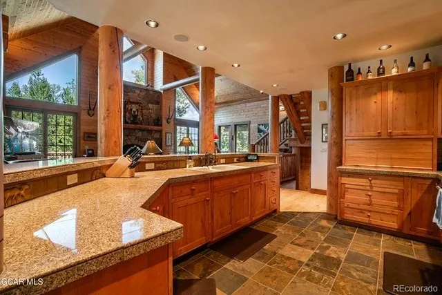 a large kitchen with stainless steel appliances granite countertop a refrigerator and a sink