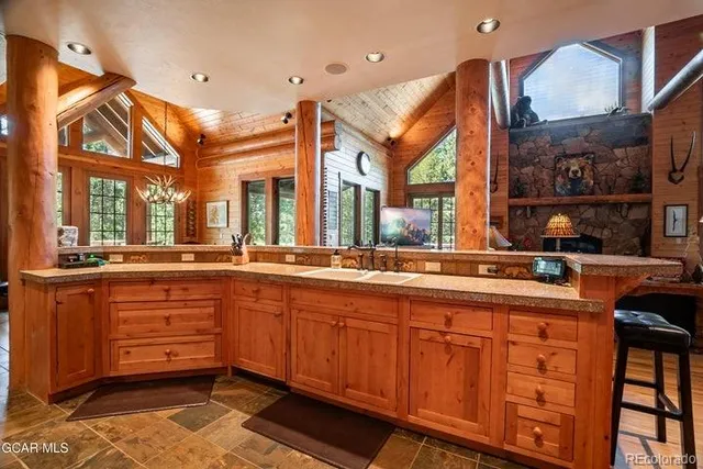 a large kitchen with stainless steel appliances a large counter top a stove and a sink