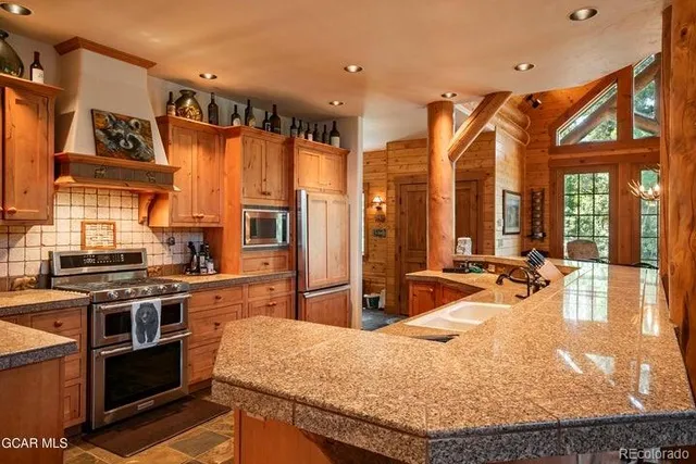 a kitchen with stainless steel appliances granite countertop a stove and a refrigerator