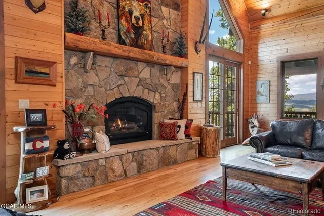 a living room with furniture a fireplace and a floor to ceiling window