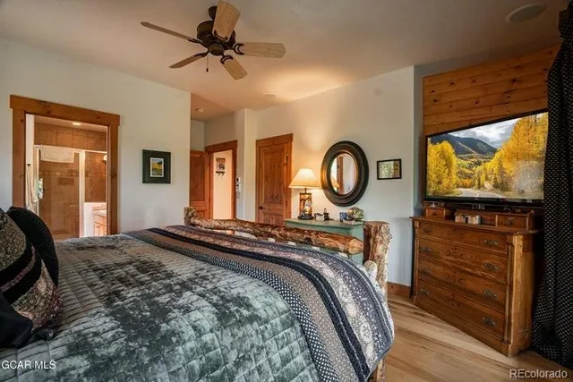 a bedroom with a bed and a flat tv screen on dresser