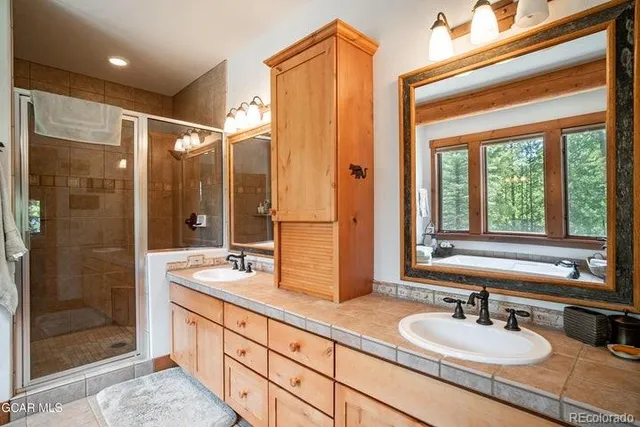 a bathroom with double vanity sinks and a shower