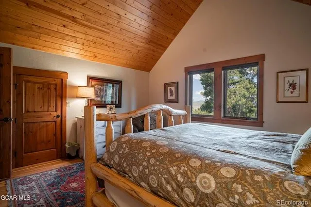 a bed sitting in a spacious bedroom next to a window