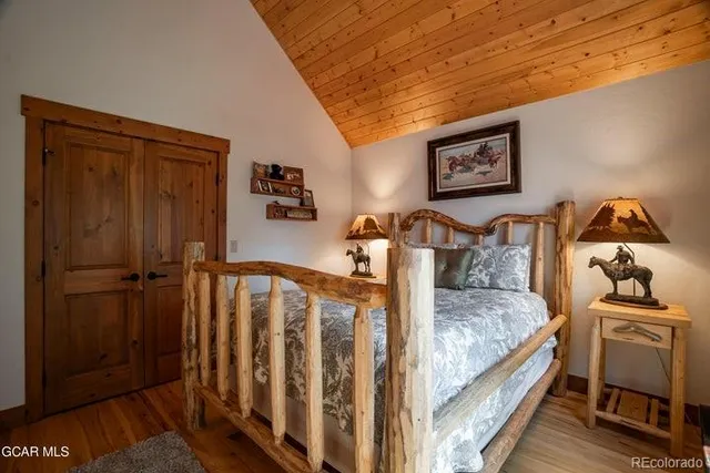 a bedroom with bed and wooden floor