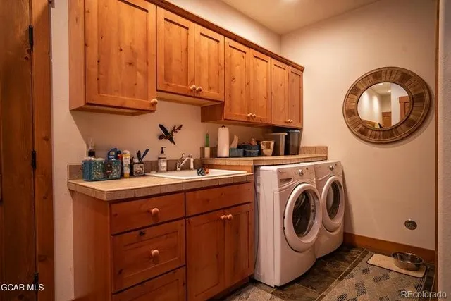 a utility room with sink dryer and washer