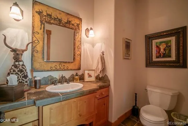 a bathroom with a toilet sink and mirror