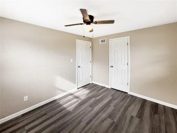a view of empty room with wooden floor