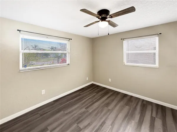 a view of an empty room with a window and a painting on the wall