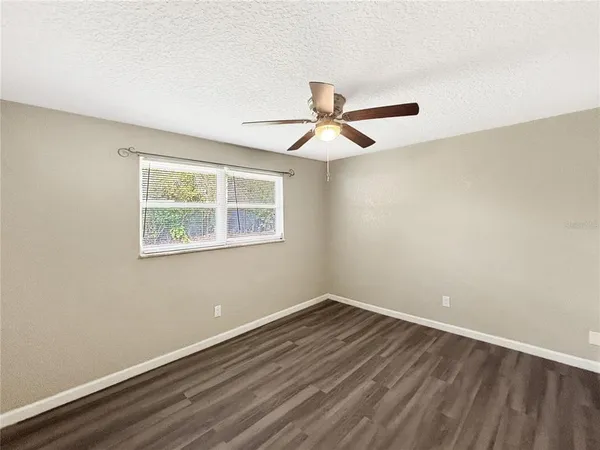 a view of a room with wooden floor and a ceiling fan