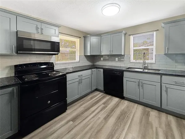 a kitchen with a sink stove and microwave