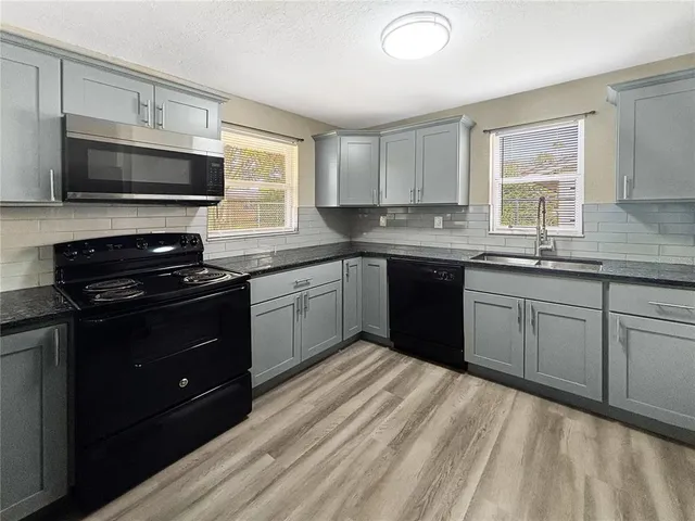 a kitchen with a sink stove and microwave