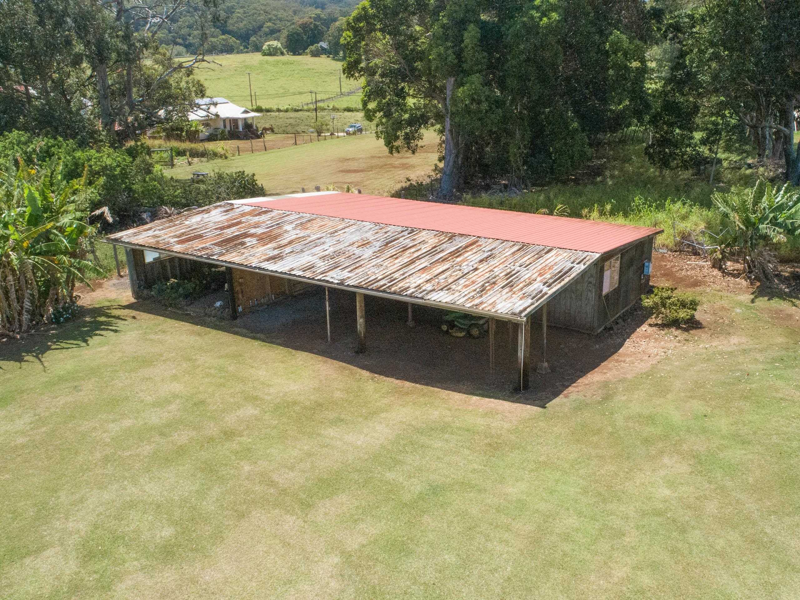 2594 Puuomalei Road Haiku, HI 96708 - Photo 17 of 30 a bed sitting in a bedroom next to a yard with large trees
