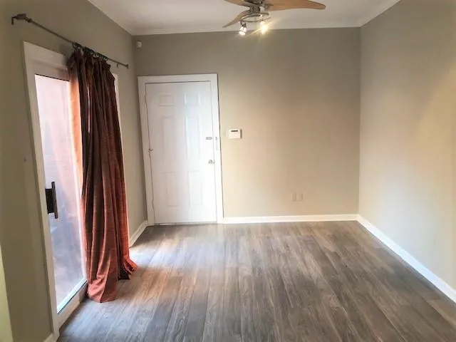 an empty room with wooden floor and a window