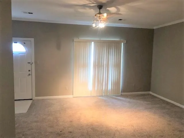 an empty room with windows and fan