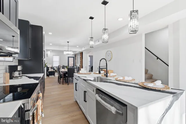 a large kitchen with kitchen island a sink appliances and a dining table view