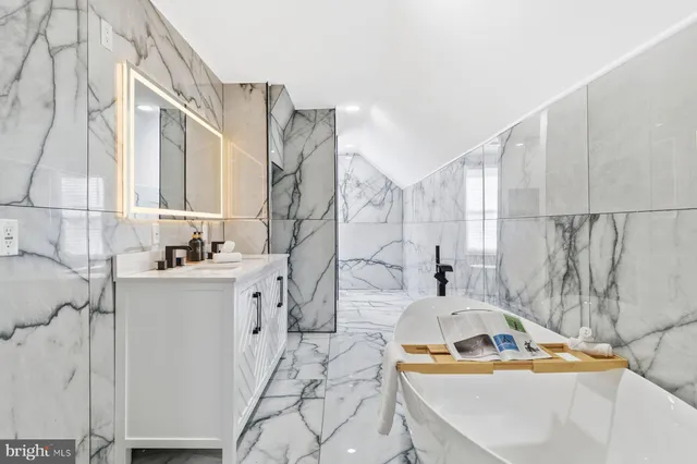 a bathroom with a tub sink and mirror