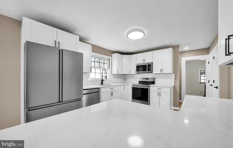 a kitchen with stainless steel appliances a stove a sink and a microwave