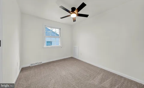 a view of empty room with ceiling fan