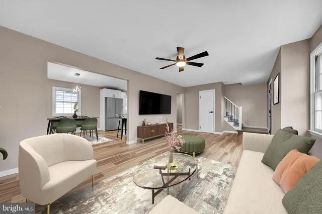 a living room with furniture kitchen view and a flat screen tv