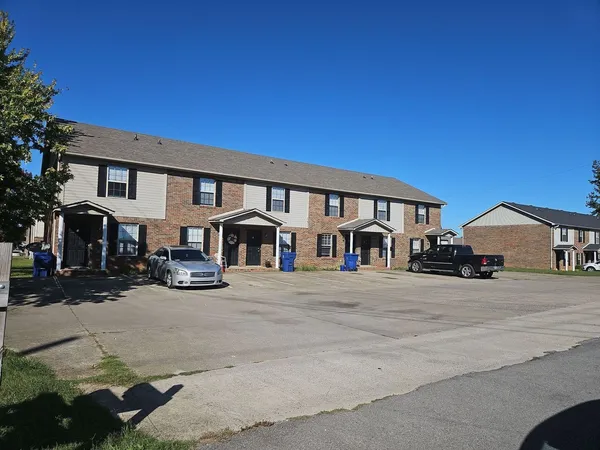 a front view of a house with cars parked in front of house
