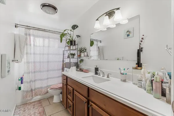 a bathroom with a sink a toilet and shower curtain