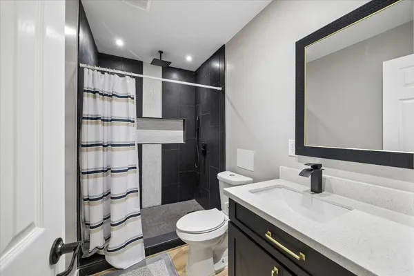 a bathroom with a sink toilet vanity and shower