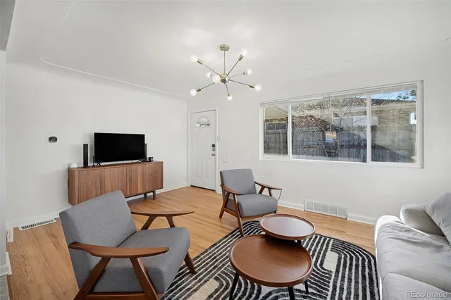 a living room with furniture a flat screen tv and a window