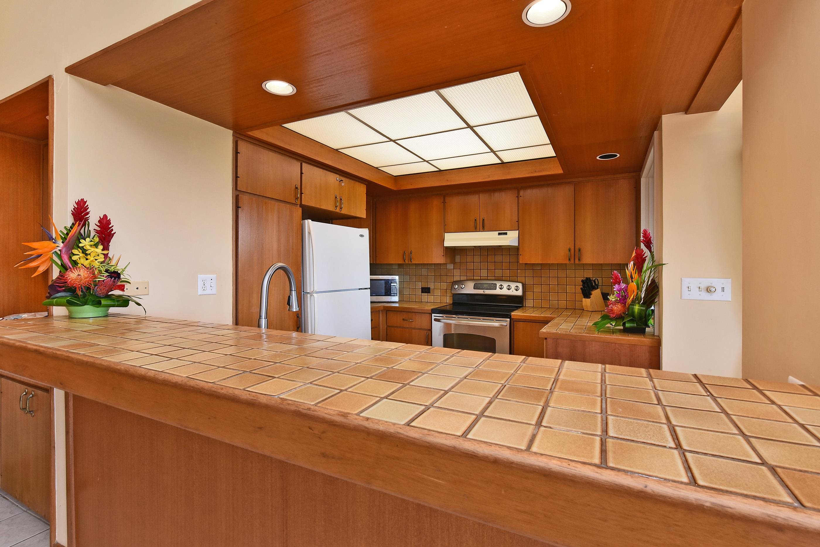 100 Ridge Road, Unit 161113 Lahaina, HI 96761 - Photo 14 of 30 a kitchen with stainless steel appliances kitchen island granite countertop a refrigerator and stove