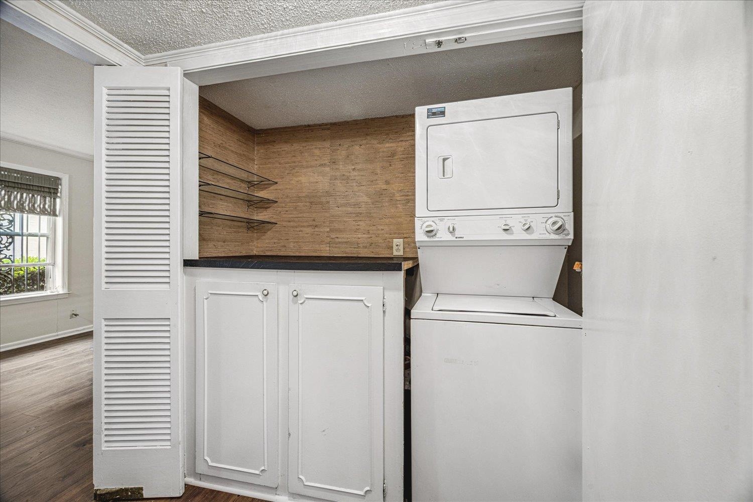 865 South Yates Road, Unit 1 Memphis, TN 38120 - Photo 18 of 25 Laundry area featuring dark wood-type flooring, stacked washer / dryer, and a textured ceiling