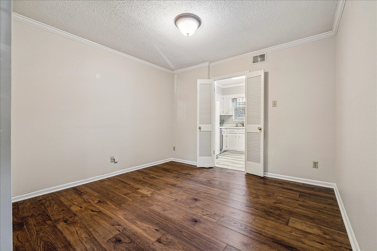 865 South Yates Road, Unit 1 Memphis, TN 38120 - Photo 19 of 25 Spare room featuring dark wood-style flooring, crown molding, and a textured ceiling