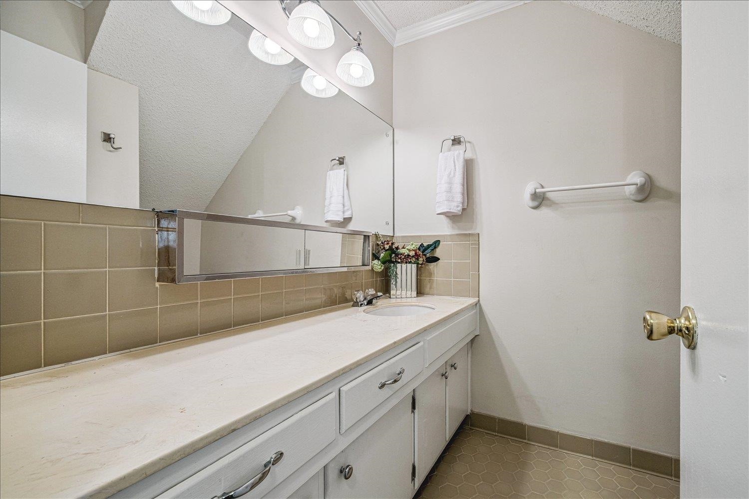 865 South Yates Road, Unit 1 Memphis, TN 38120 - Photo 20 of 25 Bathroom featuring a textured ceiling, vanity, dark tile patterned floors, and decorative backsplash
