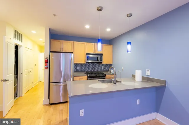 a kitchen with refrigerator a microwave a stove and a window