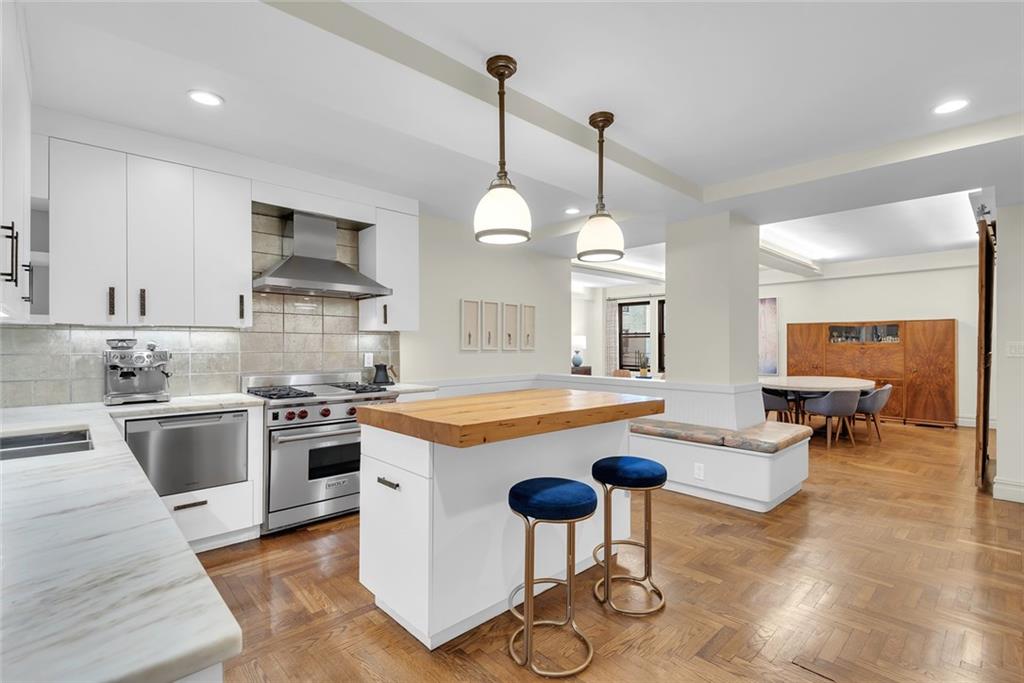 135 Eastern Parkway, Unit 7E Brooklyn, NY 11238 - Photo 3 of 17 a kitchen with stainless steel appliances granite countertop a stove a sink a oven a dining table and chairs