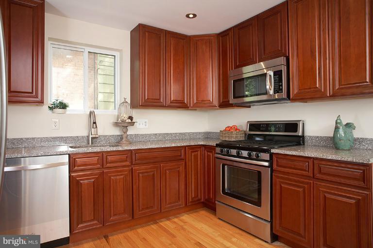 11204 Monticello Avenue Silver Spring, MD 20902 - Photo 12 of 29 a kitchen with granite countertop wooden cabinets and stainless steel appliances