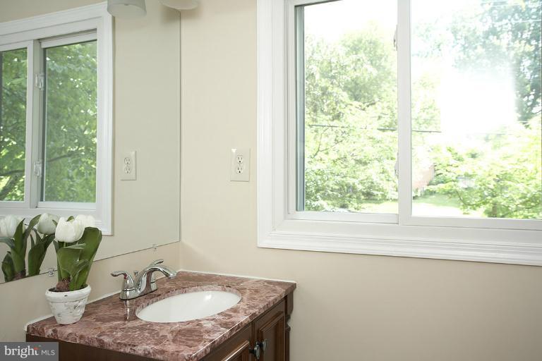11204 Monticello Avenue Silver Spring, MD 20902 - Photo 19 of 29 a bathroom with a granite countertop sink a mirror and a window