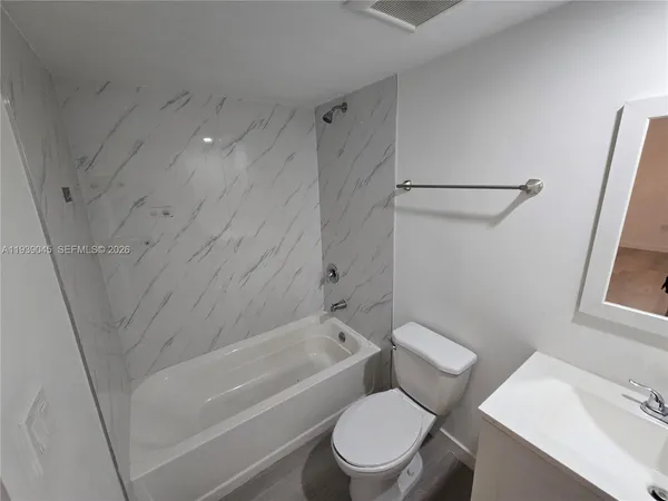 a white toilet sitting next to a bath tub